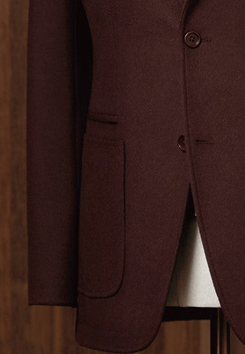 Close-up of men's burgundy blazer pocket and single-button detail, showcasing tailored craftsmanship and a refined finish. Ideal for eco-conscious shoppers seeking sustainable, high-end fashion.