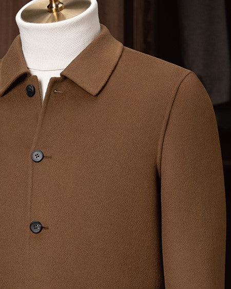 Close-up of a men's camel tailored jacket with a structured collar and classic buttons, showcasing fine craftsmanship and premium eco-friendly fabric for sustainable style.