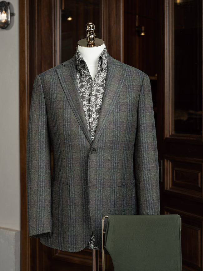 Close-up of a tailored checked wool jacket with olive trousers, showcasing sustainable materials and refined details for a sophisticated, eco-friendly formal look.