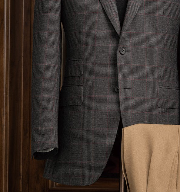 A luxurious ensemble featuring a dark grey checked jacket and beige trousers, ideal for formal events with a touch of sophistication.