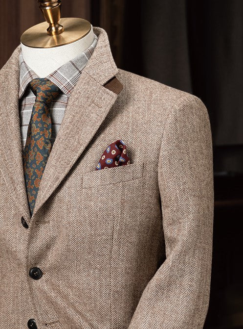 Elegant beige men's tweed blazer on a mannequin with a plaid shirt, floral tie, and pocket square Close up of the pocket square and peak lapels