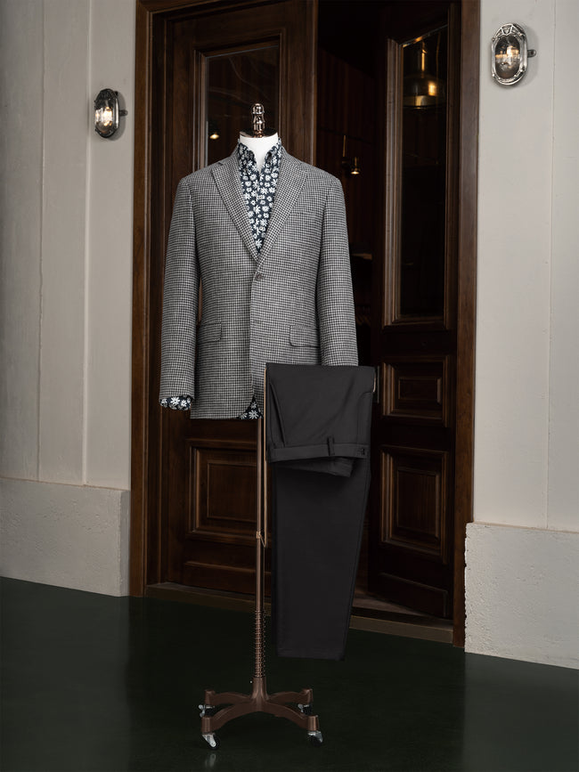 A sophisticated grey houndstooth blazer paired with black trousers, perfect for both formal and semi-formal occasions.