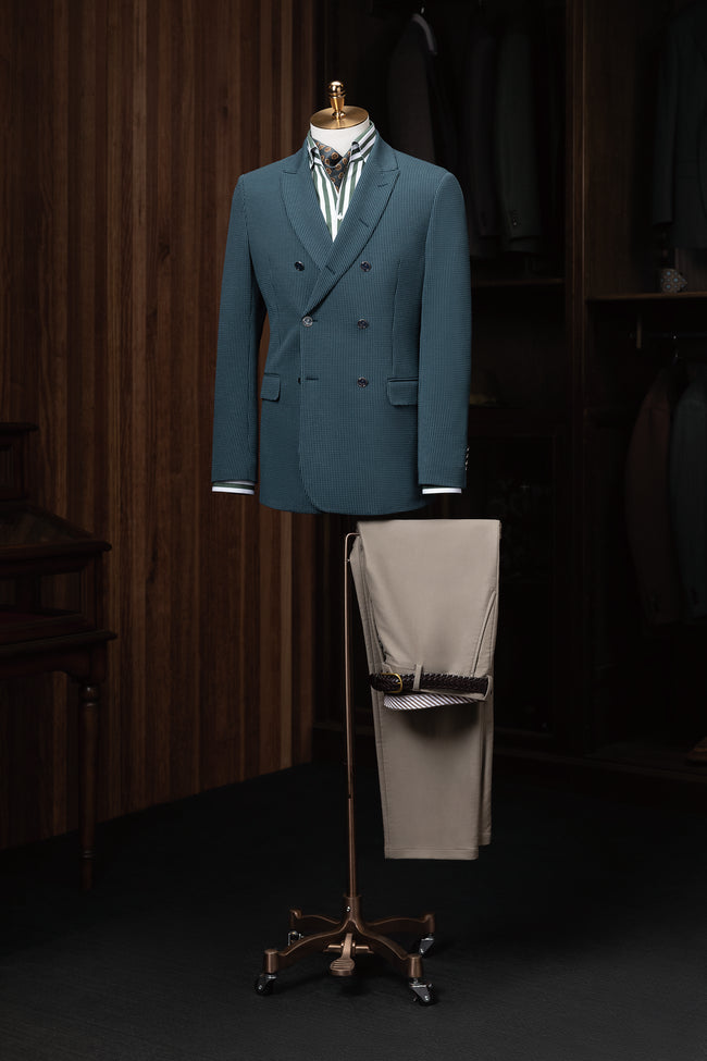 A chic teal double-breasted jacket paired with beige trousers, ideal for a refined and modern look.