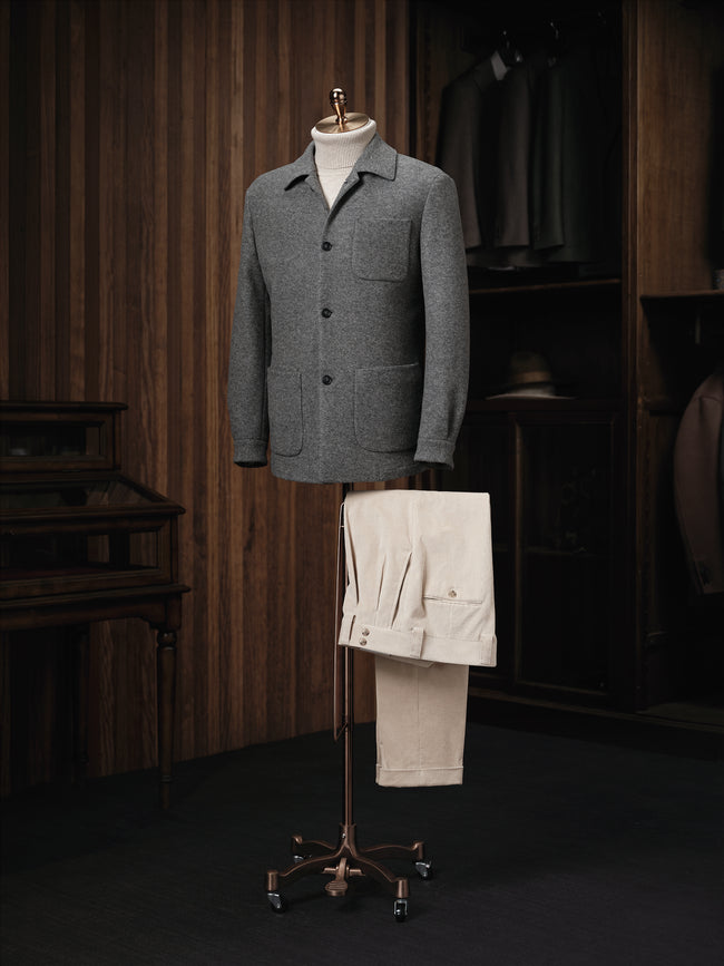 Complete outfit display featuring a grey wool blend patch pocket jacket paired with pleated cream corduroy trousers — styled for contemporary elegance in winter wardrobes.