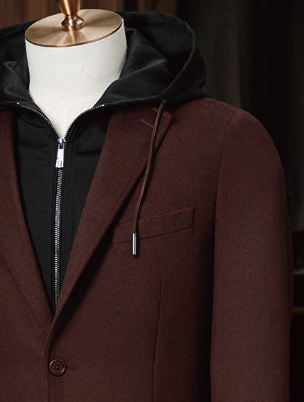 Close-up of men's burgundy blazer with peaked lapels and black hoodie underlayer, featuring a stylish blend of formal and casual elements. Perfect for eco-conscious shoppers seeking high-end, sustainable fashion with versatile appeal.