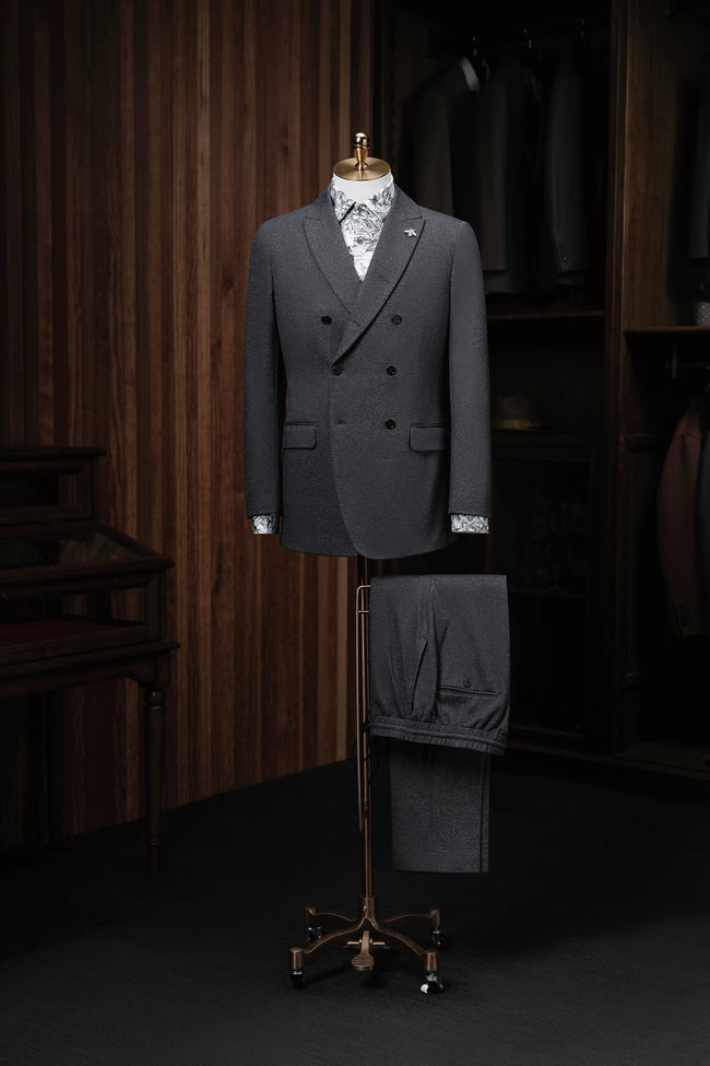 Elegant charcoal grey double-breasted suit on a mannequin, showcasing high-end tailoring for men. Perfect for formal events, crafted with sustainable materials.