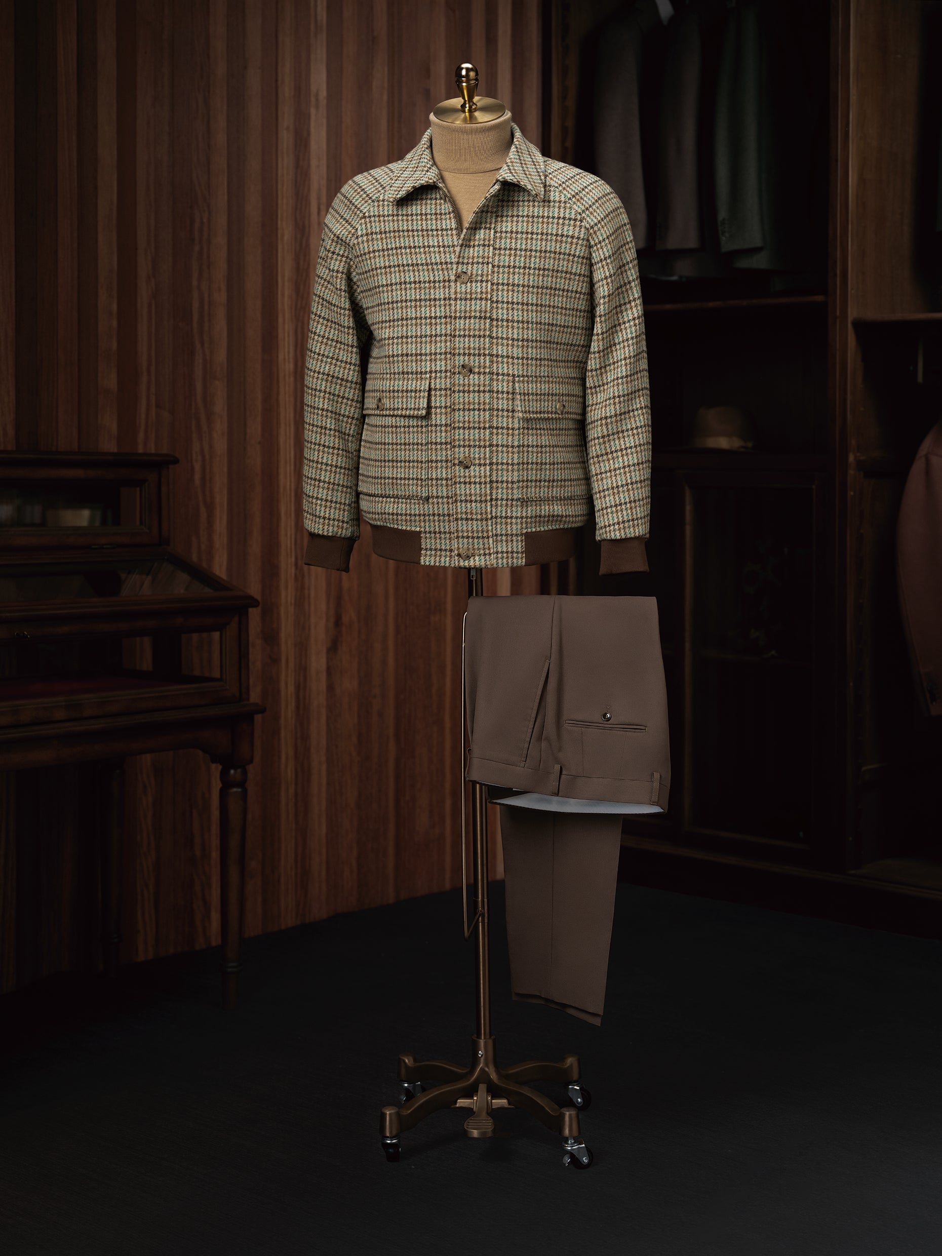 Checked field jacket paired with brown khaki trousers on a mannequin, showcasing eco-friendly, high-end tailoring for women, perfect for formal elegance.