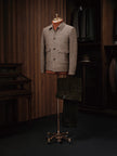 Mannequin displaying a tailored houndstooth field jacket paired with brown corduroy trousers, crafted from sustainable materials for an elegant formal look.