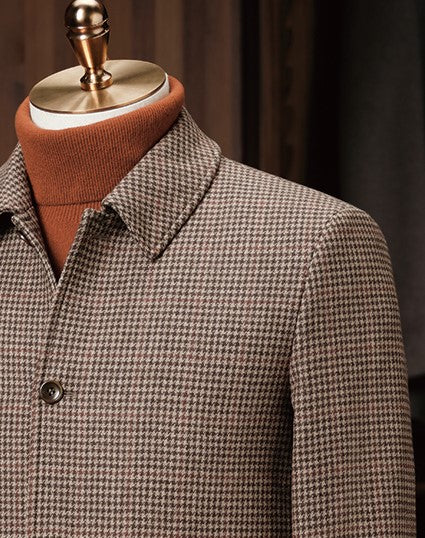 Close-up of houndstooth field jacket collar and shoulder, showcasing fine tailoring, sustainable fabric, and classic design, perfect for a sophisticated look.
