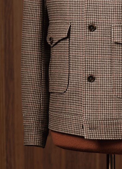 Close-up of houndstooth field jacket pocket and sleeve, showcasing sustainable fabric, refined tailoring, and classic design details, ideal for formal elegance.