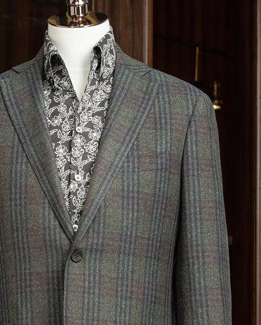 Close-up of checked wool jacket lapels and shoulder, featuring sustainable materials and detailed tailoring, ideal for a polished and refined formal look.