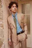 Full view of classic soft beige double-breasted suit, featuring a tailored fit, paired with a blue shirt and green tie, ideal for sophisticated, formal style.