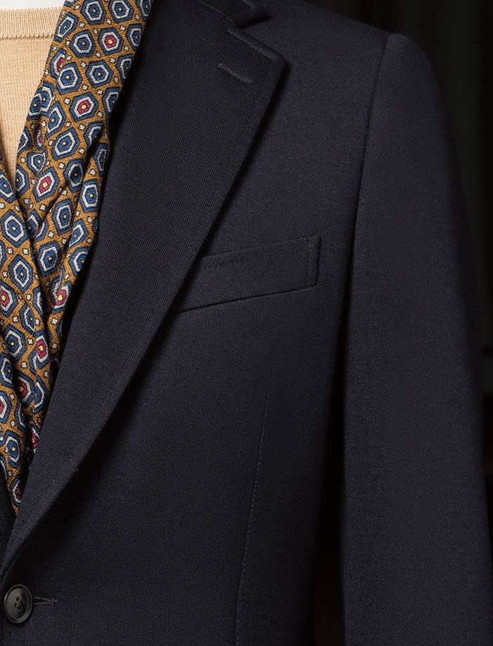 Detailed view of the navy blazer's peak lapels and pocket, showcasing fine tailoring for a sophisticated formal outfit for women.