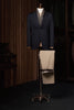 Classic navy blazer with beige trousers displayed on a mannequin. High-quality tailored clothing for women who desire a luxury feel for formal occasions.