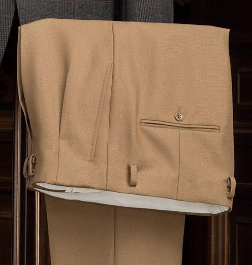 Elegant beige tailored trousers with side adjusters, highlighting premium craftsmanship and meticulous stitching. Ideal for refined formalwear.