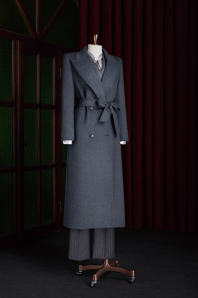 Full-length dark grey overcoat on a mannequin, featuring a waist tie belt and elegant double-breasted buttons, ideal for a sophisticated winter wardrobe.