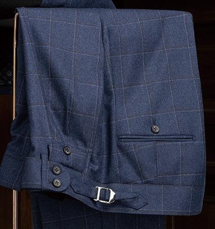 Deep blue check suit trousers with adjustable side tabs and button details for a tailored fit and refined style.