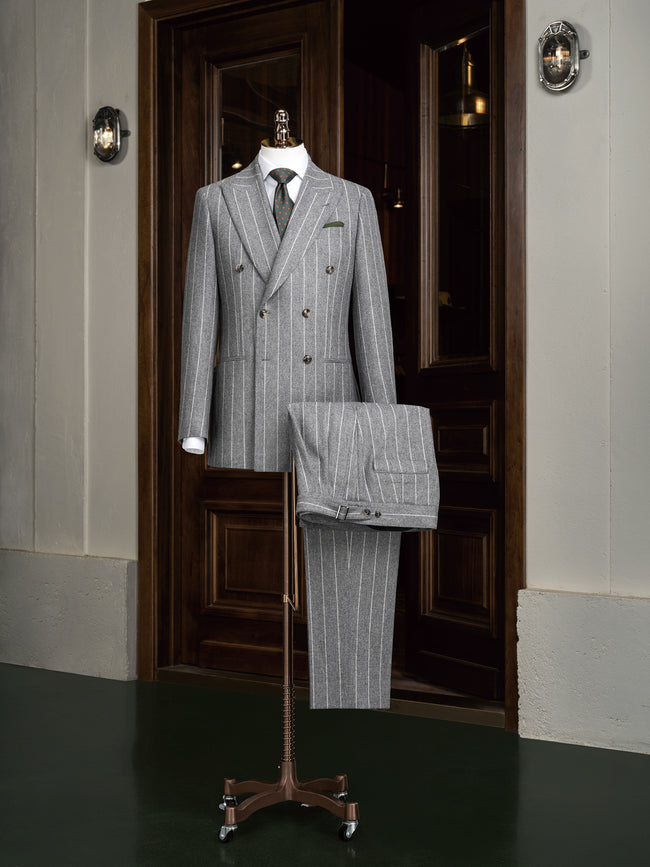 Elegant light grey double-breasted suit on a mannequin, showcasing high-end tailoring for men. Perfect for formal events, crafted with sustainable materials.