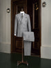 Elegant light grey double-breasted suit on a mannequin, showcasing high-end tailoring for men. Perfect for formal events, crafted with sustainable materials.