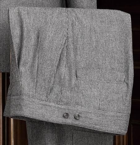 Close-up of grey suit trousers, showcasing fine textured fabric, precise tailoring, and back pocket detail, perfect for a sophisticated formal look.