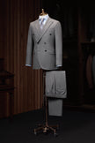 Elegant double-breasted wool suit on a mannequin, showcasing high-end tailoring for men. Perfect for formal events, crafted with sustainable materials.