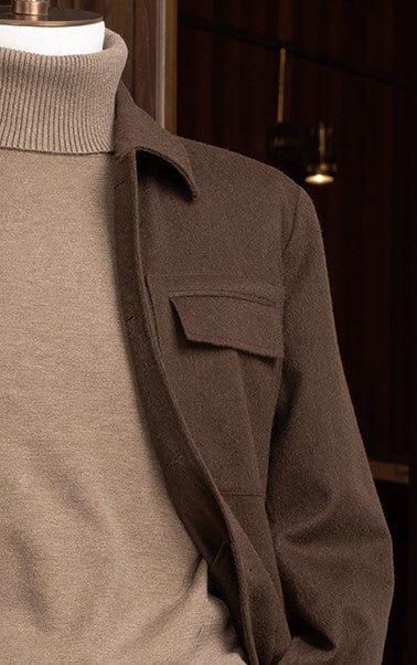 Close-up of a earthy brown jacket and matching cargos, paired with a beige turtleneck and for a refined, high-end look.