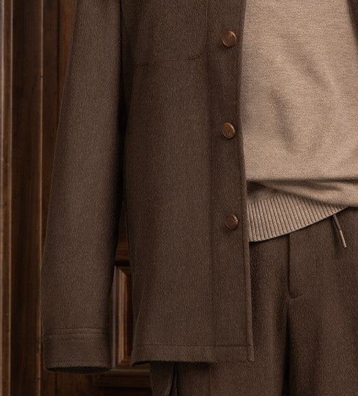 Close-up view of an earthy brown jacket and cargos, showcasing fine tailoring and sophisticated style for formal occasions.