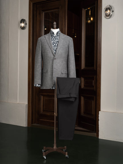 A sophisticated grey houndstooth blazer paired with black trousers, perfect for both formal and semi-formal occasions.