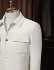 Upper close-up of The Couturist's white tailored jacket, featuring stylish patch pockets and collar. High-quality craftsmanship for women’s formalwear