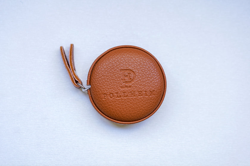 Front view of the POLLHEIM premium retractable measuring tape, featuring a textured brown leather case with embossed logo – ideal for bespoke tailors and precision fitting.